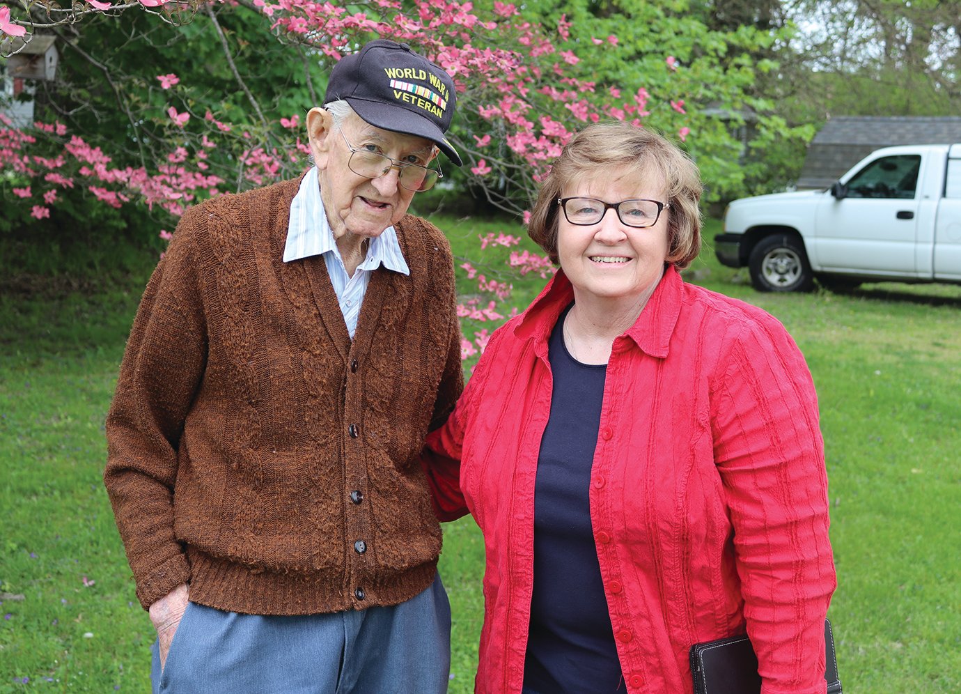 Archie Krout and neighbor Debbie Threlkeld celebrate his 98th birthday in 2020 outside Krout's home as they await a surprise parade honoring the World War II veteran. Dozens of friends, family, fellow veterans and members of the community were on hand, either alongside Krout or honking while displaying signs of appreciation as they drove past.